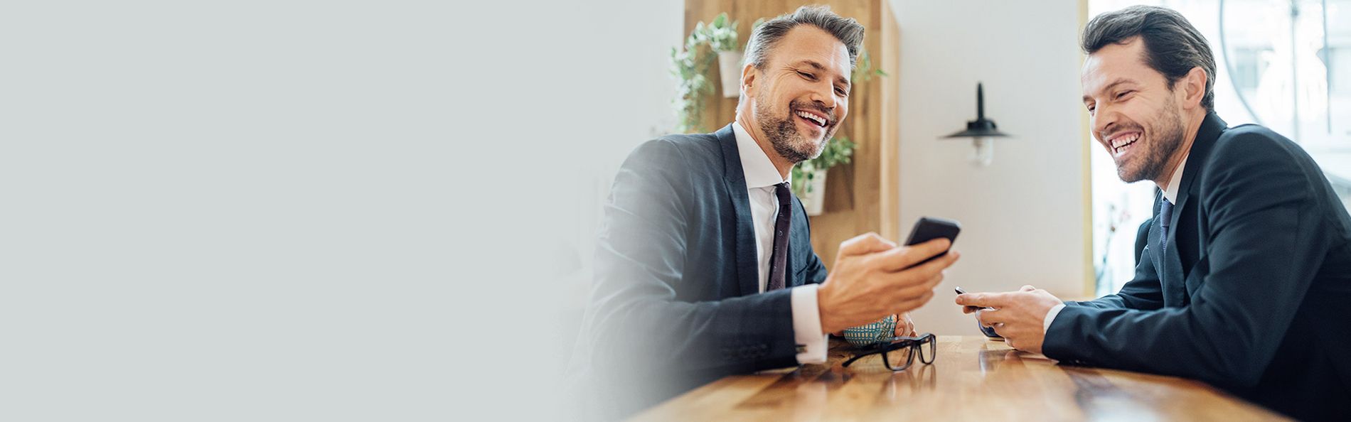 Zwei Männer lachen und schauen auf ein Handy