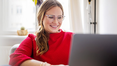 Lachende Frau vor Laptop