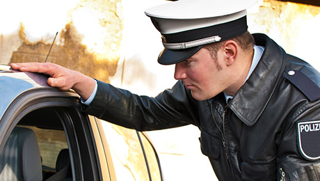 Polizist blickt in ein Auto